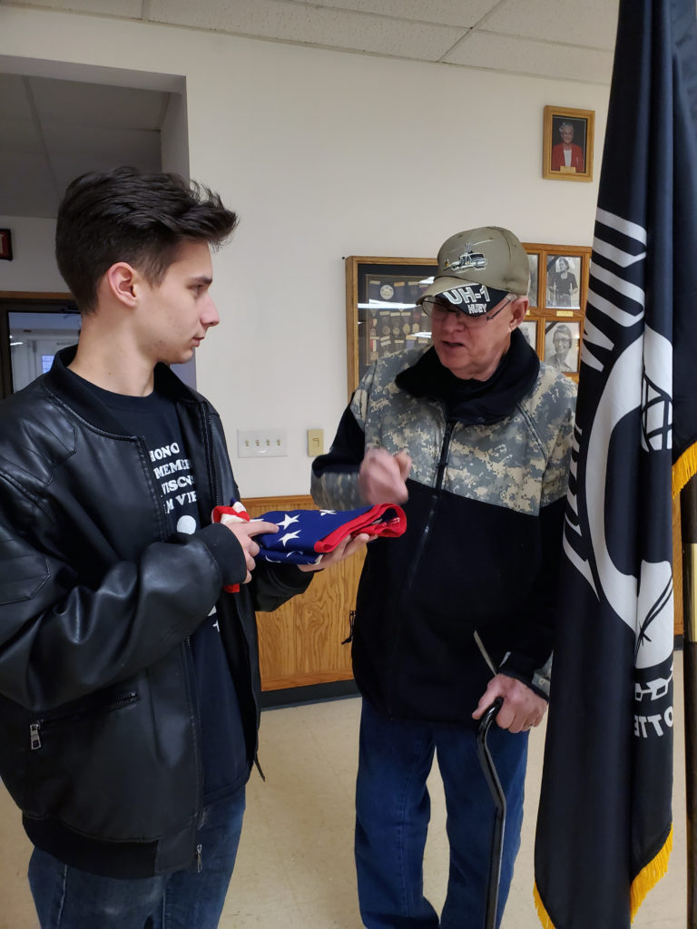 Mike Duncan explaining the story and significance of this folded flag to Jordan.